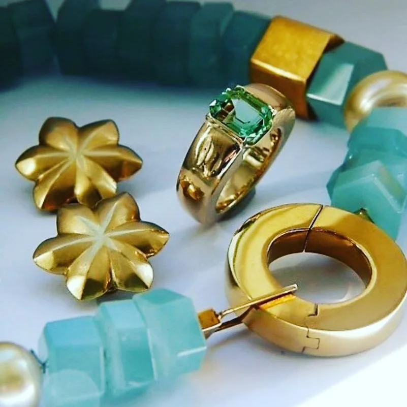 Goldene Blütenohrstecker und Creolen, dazu ein Ring und türkisfarbene Steine