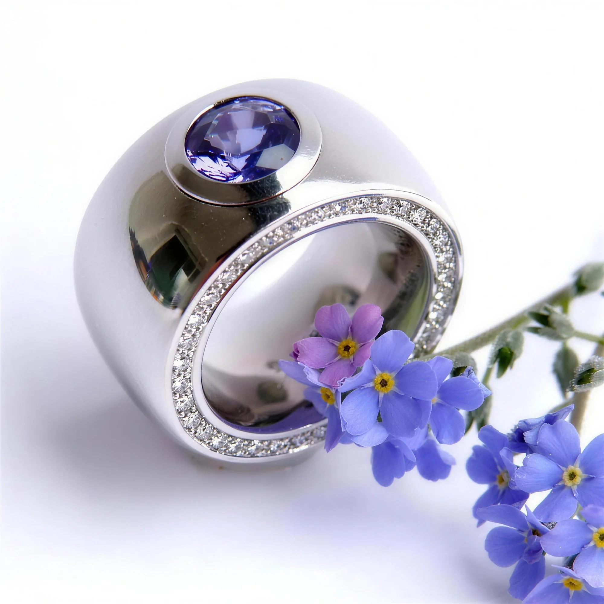 Breiter Weißgoldring mit violettem Tansanit und umlaufendem Brillantpavé