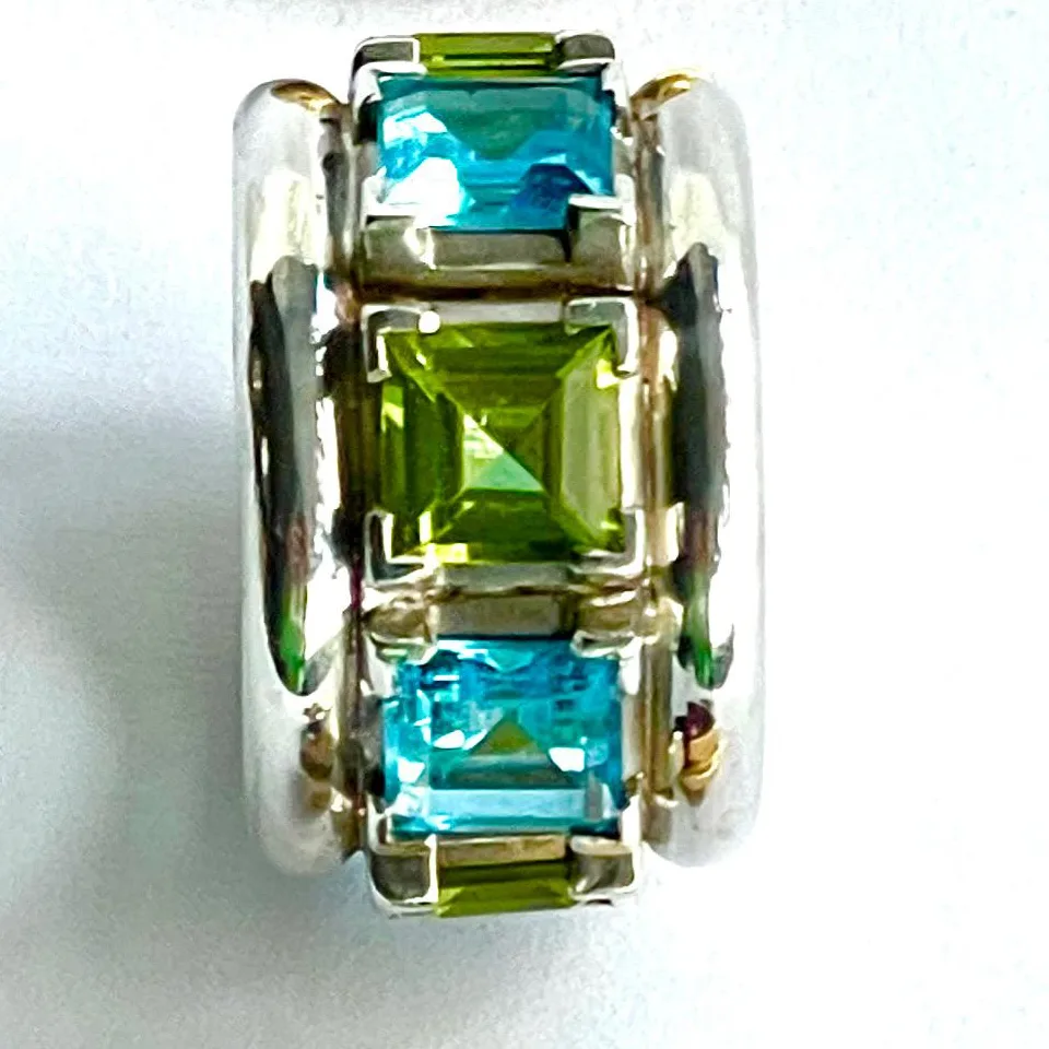 Weißgoldring mit grünen Peridoten und blauen Topasen, rundum gefasst