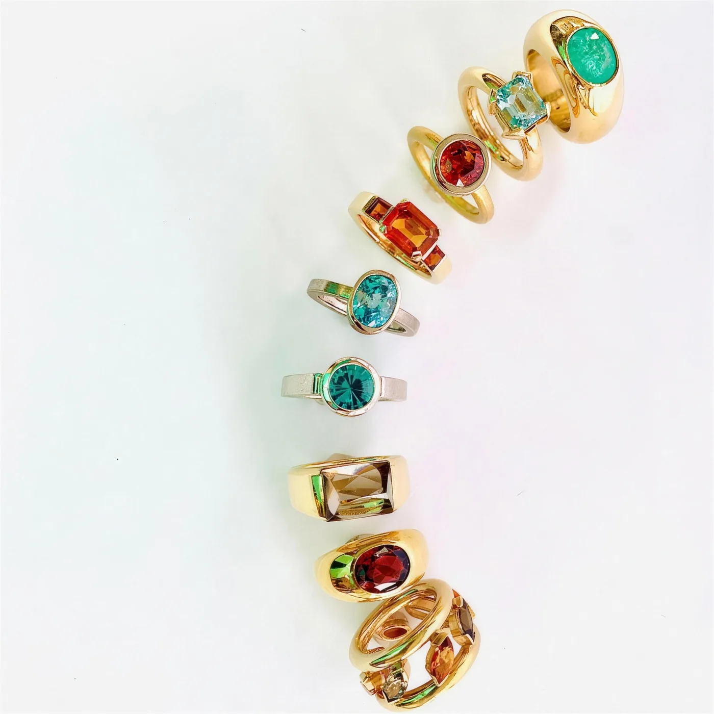 Ringe mit Smaragd, Aquamarin, Citrin und Granat, in geschwungener Reihe arrangiert